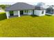 Backyard view of modern home with large covered patio at 1094 Rotonda Cir, Rotonda West, FL 33947