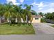 Single-story home with a large driveway and palm trees at 521 Live Oak St, Venice, FL 34285