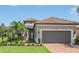 Single-story home with gray exterior, two-car garage, and landscaped yard at 4507 Terrazza Ct, Bradenton, FL 34211