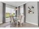 Elegant dining room with glass table, taupe chairs, and large window at 4507 Terrazza Ct, Bradenton, FL 34211