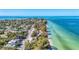 Aerial view of homes near a picturesque beach with turquoise waters and a long pier, ideal for coastal living at 136 Crescent Dr, Anna Maria, FL 34216