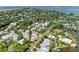 Aerial view of a residential area with lush landscaping, waterfront homes, and bay views at 136 Crescent Dr, Anna Maria, FL 34216