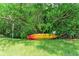 Backyard featuring a yellow kayak nestled under a large tree near a No Boat Launch sign at 136 Crescent Dr, Anna Maria, FL 34216