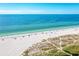 Beautiful beach with crystal-clear blue waters, people relaxing on the sand, and lush vegetation in the background at 136 Crescent Dr, Anna Maria, FL 34216