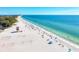 Expansive beach featuring volleyball nets, a lifeguard station, and many beach umbrellas and people enjoying the sun at 136 Crescent Dr, Anna Maria, FL 34216