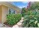Charming home with lush landscaping, stone walkway and beautiful flowering plants at 136 Crescent Dr, Anna Maria, FL 34216