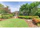 Charming home with vibrant landscaping, featuring stepping stones and lush tropical plants at 136 Crescent Dr, Anna Maria, FL 34216