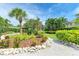 Beautifully landscaped yard with a variety of plants, trees, and decorative rock borders at 136 Crescent Dr, Anna Maria, FL 34216