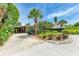 Well-maintained property featuring a spacious driveway and meticulously manicured landscaping at 136 Crescent Dr, Anna Maria, FL 34216