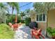 A charming outdoor patio features Adirondack chairs, stone pavers, and lush tropical landscaping at 136 Crescent Dr, Anna Maria, FL 34216