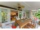 Cozy porch featuring tropical landscaping, a ceiling fan, and access to the main living area at 136 Crescent Dr, Anna Maria, FL 34216