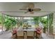 Covered porch with tropical landscaping, ceiling fan, and outdoor seating creating a serene space at 136 Crescent Dr, Anna Maria, FL 34216