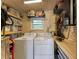 Utility room with washer, dryer, storage shelves, and workbench at 136 Crescent Dr, Anna Maria, FL 34216