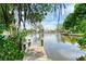 Scenic waterfront view from the wooden dock, featuring lush greenery and calm waters at 136 Crescent Dr, Anna Maria, FL 34216