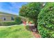 A partial view of a lush green yard, mature trees, and a patio area with outdoor seating at 136 Crescent Dr, Anna Maria, FL 34216