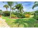 Expansive front yard with lush lawn, mature landscaping, and a stone walkway leading to the home at 136 Crescent Dr, Anna Maria, FL 34216