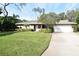 Single-story house with a two car garage and manicured lawn at 1833 Sandalwood Dr, Sarasota, FL 34231