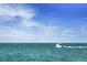 A white boat is seen sailing on the blue ocean under a clear sky at 19369 Nearpoint Dr, Venice, FL 34292