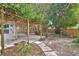 Landscaped backyard with wood pergola, concrete patio, stone path, and wood fence at 2912 Pinecrest Way, Sarasota, FL 34239