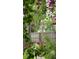 Backyard with a wooden fence and flowers, showcasing a serene landscape with natural light filtering through the trees at 2912 Pinecrest Way, Sarasota, FL 34239