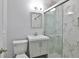 Contemporary bathroom featuring shower with glass doors, gray vanity, and white marble at 2912 Pinecrest Way, Sarasota, FL 34239