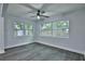 Bright bedroom with a ceiling fan, hardwood-style flooring, and multiple windows for natural light at 2912 Pinecrest Way, Sarasota, FL 34239
