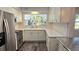 Well-lit kitchen with stainless steel appliances, white cabinets, modern backsplash, and durable countertops at 2912 Pinecrest Way, Sarasota, FL 34239