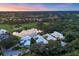 Stunning aerial view of a luxurious community with lush landscaping, a serene pond, and well-manicured grounds at 7620 Club Ln, Sarasota, FL 34238
