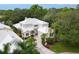 Gorgeous home with a white roof, lush landscaping, and a private driveway nestled in a golf community at 7620 Club Ln, Sarasota, FL 34238