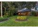 Serene backyard oasis with lush landscaping, a screened-in porch, and mature trees for privacy at 7620 Club Ln, Sarasota, FL 34238