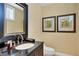 Elegant powder room featuring a black vanity with granite countertop and decorative wall art at 7620 Club Ln, Sarasota, FL 34238