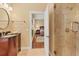 Bright bathroom features a vanity with dark wood cabinets, and walk-in shower with glass door at 7620 Club Ln, Sarasota, FL 34238