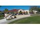 Exterior view of the clubhouse with outdoor seating, manicured landscaping, and elegant architecture at 7620 Club Ln, Sarasota, FL 34238