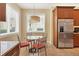 Bright eat-in kitchen featuring a table with seating, stainless steel refrigerator, and natural light at 7620 Club Ln, Sarasota, FL 34238