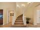 Elegant foyer featuring a curved staircase with white railings and neutral carpeting leading to the upper level at 7620 Club Ln, Sarasota, FL 34238