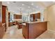 Spacious kitchen features wood cabinets, granite countertops, dual chandeliers, and a built-in desk area at 7620 Club Ln, Sarasota, FL 34238