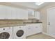 Well-equipped laundry room with granite countertops, ample storage, and modern appliances for convenience at 7620 Club Ln, Sarasota, FL 34238