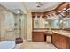 Luxurious main bathroom featuring a glass-enclosed shower, soaking tub, custom cabinetry, and elegant lighting at 7620 Club Ln, Sarasota, FL 34238