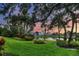 Beautiful pond view from a well-manicured lawn with mature trees and landscaping, offering a serene outdoor setting at 7620 Club Ln, Sarasota, FL 34238