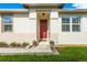 Inviting home exterior with red door and landscaping at 8798 Tuscany Isles Dr, Punta Gorda, FL 33950