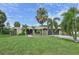 Single-story home with a large grassy yard and mature palm trees at 6106 45Th W St, Bradenton, FL 34210