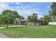 Side view of a single-story house with a grassy yard and palm trees at 6106 45Th W St, Bradenton, FL 34210