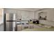 Small kitchen with white cabinets, stainless steel appliances, and light countertops at 400 Base E Ave # 229, Venice, FL 34285