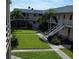 Exterior view of an apartment building with a grassy courtyard at 400 Base E Ave # 229, Venice, FL 34285