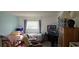 Small bedroom with two twin beds, a TV, and an antique cabinet at 400 Base E Ave # 229, Venice, FL 34285