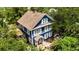 Aerial view of a charming blue two-story home with mature trees and a well-maintained yard and landscaping at 1332 3Rd W Ave, Bradenton, FL 34205