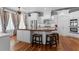 Spacious kitchen with white cabinetry, stainless steel appliances, an island with seating, and hardwood floors at 1332 3Rd W Ave, Bradenton, FL 34205
