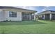 Beautiful backyard view featuring a well-manicured lawn, screened-in lanai, and lush landscaping at 18773 Dayspring Pl, Venice, FL 34293