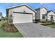 Beautiful home featuring a spacious garage, manicured landscaping, and an inviting paver driveway at 18773 Dayspring Pl, Venice, FL 34293