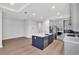 Spacious kitchen with stainless steel appliances, center island, hardwood floors, and custom lighting at 18773 Dayspring Pl, Venice, FL 34293